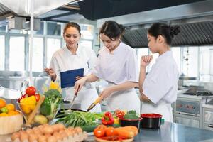 Young Chefs Learning to Cook with Fresh Ingredients, Culinary Instructor Guides Students in a Professional Kitchen photo