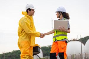 Environmental Workers Inspecting Industrial Site, Team in Protective Gear Surveying Contaminated Area, Engineer and Environmental Worker Shaking Hands at a Chemical Plant photo