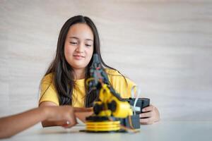 Young Girl Engaged in Robotics Learning and Building, Female Student Focusing on Her STEM Robotics Project, Curious Child Interacting with a Robotic Arm Kit photo