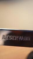 Metallic reserved sign resting on restaurant table, shifting camera angles highlighting focus and depth of hospitality environment, revealing subtle details of dining reservation video