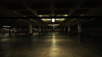 Underground parking garage revealing concrete columns and floors, illuminated by fluorescent lights, standing empty and silent, showcasing architectural design with urban infrastructure perspective video
