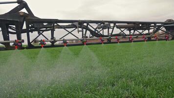 Agricultural Spraying in Action, Nozzles Dispersing Liquid Evenly Over Young Green Wheat Field video
