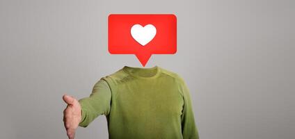 A person reaches out with a hand for a virtual handshake. Above their head is a speech bubble with a heart icon, symbolizing social media interactions and connections in the digital age. photo