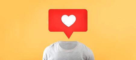 A unique representation showcases a torso in a plain shirt with a red speech bubble above it. The speech bubble contains a white heart symbol, emphasizing social media connections and engagement. photo