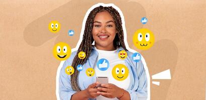 A young African American woman smiles while texting on her smartphone, surrounded by various playful emoji icons. She seems engaged in lively conversation, expressing joy through digital interaction. photo