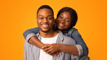 Closeup Shot Of Happy Romantic Young African American Couple Embracing And Smiling At Camera, Loving Millennial Black Man And Woman Hugging While Posing Together Over Yellow Background, Free Space photo