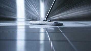 A mop glides across sleek tiles, reflecting light in a well-lit indoor area, showcasing cleanliness. photo