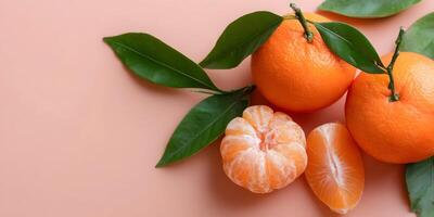 three oranges with leaves on a pink background photo