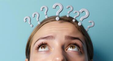 Young woman looking up with question marks above head symbolizing confusion and thought photo