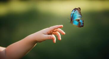 Little child hand reaching out towards a vibrant blue butterfly in flight. photo