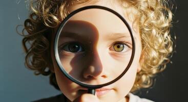 Curious child with magnifying glass exploring and discovering the world photo