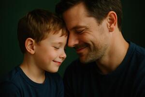 Happy father and young son in a close up portrait, foreheads touching photo
