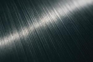 Textured brushed metal surface with fine vertical lines and light reflection photo