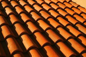 Close up of terracotta roof tiles in an overlapping pattern on a mediterranean villa under bright sunlight photo