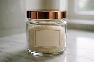 Elegant glass jar with white bath salts and rose gold lid on marble counter photo