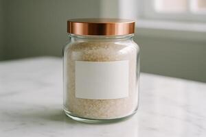 Clear glass jar with copper lid and blank label filled with bath salts photo
