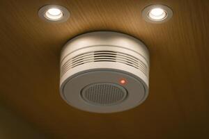 Close up of a modern white smoke detector with a red indicator light on a wooden ceiling photo