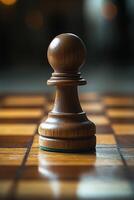 Wooden pawn standing on chessboard awaits next move photo