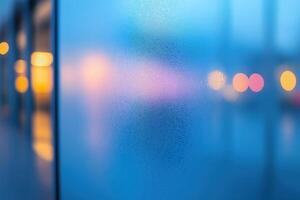Condensation forming on glass window during cold evening with city lights blurred in background photo