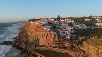 Azenhas do Mar Village in Portugal at Sunset, Cliffs and Waves of Atlantic Ocean. Aerial View. Moving Backwards and Upwards video