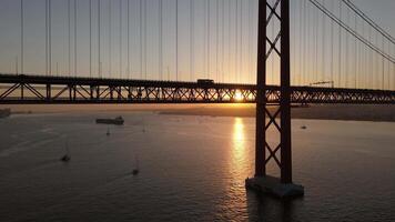 Ponte 25 de Abril Suspension Bridge over Tagus River at Sunset. 25th April Bridge. Portugal. Aerial View. Sun is Peeking through the Construction video