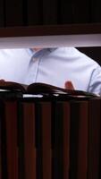 A man is looking at a book in a bookcase video