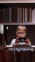 A boy in glasses is using a tablet computer video