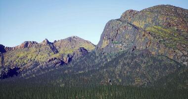 Serene concept of CGI Majestic mountain range with dense forest under clear blue sky video