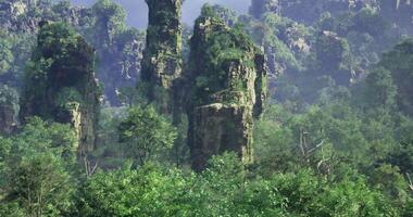 Enhanced CGI Majestic rock formations rise above lush greenery in a serene landscape video