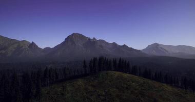Digitally-created CGI Majestic mountain landscape under clear blue sky at dusk video