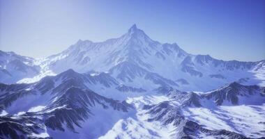CGI Majestic mountain range with snow capped peaks under clear blue sky video