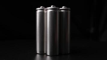 Rotating Metallic Batteries in Studio Setting with Dark Background and Reflective Surface Effect video