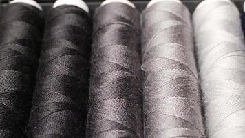 Close-up of Various Black and White Sewing Threads in a Textile Workshop Environment video