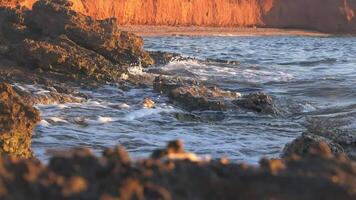Remote seashore and cliff and crashing waves, slow motion video