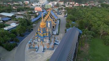Aerial view of Wat Paknam Blue Temple in Chiang Rai, Thailand, showcasing its striking blue and gold architecture in peaceful urban setting. video
