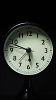 Vertical time lapse of an alarm clock time passing over a day to night on black background. video