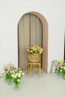 A beautiful basket of colorful tulips paired with a minimalist archway creates a charming floral setup that enhances the aesthetic appeal of any space, making it more inviting and attractive photo