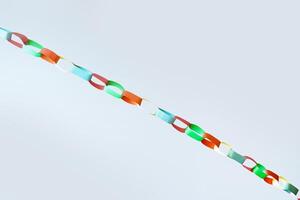 Diagonal view of multicolored paper chain garland hanging against white backdrop, fun and celebration, ideal for illustrating concepts of holidays, crafting, childhood activities, or decorative art photo