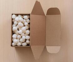Top view of biodegradable with corn-based packing peanuts inside a kraft shipping box. Perfect visual for logistics, packaging industry, and online shopping themes photo