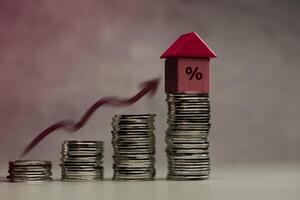 Stacked coins with house and percentage symbol representing mortgage interest rates photo