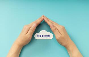 Hands shielding password on cloud symbol, representing Cybersecurity, data privacy, and online protection. Top View photo