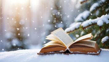 Open Book Resting on Snow with Evergreen Branch and Falling Snowflakes in a Winter Wonderland photo