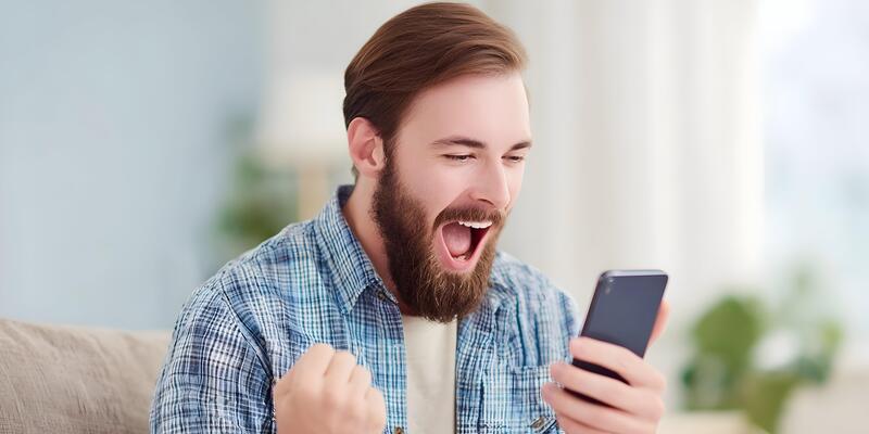 a man with a beard and a shirt is laughing while using his phone