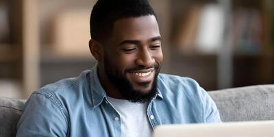 Smiling African American Man Using Laptop Computer at Home photo