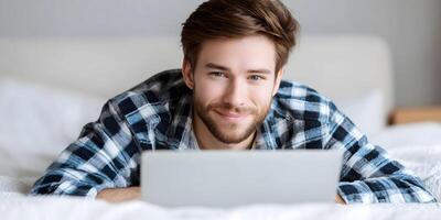 Smiling Man Lying in Bed Using Laptop Computer Happy Person Relaxing on Bedding Modern Technology Home Lifestyle photo