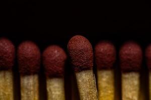 Dramatic Macro Close-Up of Red Matchstick Heads in Dark Setting photo
