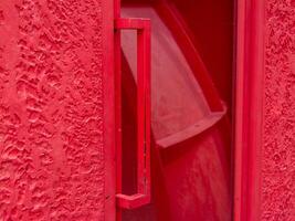 Red door handle urban setting close-up vibrant environment artistic perspective photo