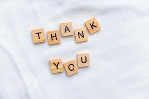 Gratitude expression in business context office setting wooden blocks minimalist environment close-up view emotional impact photo