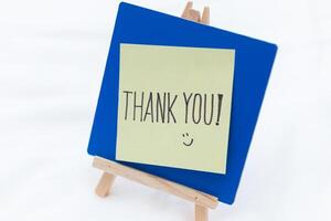 Thank you note displayed on easel business setting positive emotions minimalist environment close-up view gratitude concept photo