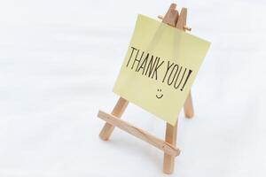 Thank you note on mini easel home office appreciation gesture minimalist setup close-up view business gratitude concept photo